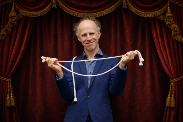 Zauberer mit weißem Seil im Rampenlicht